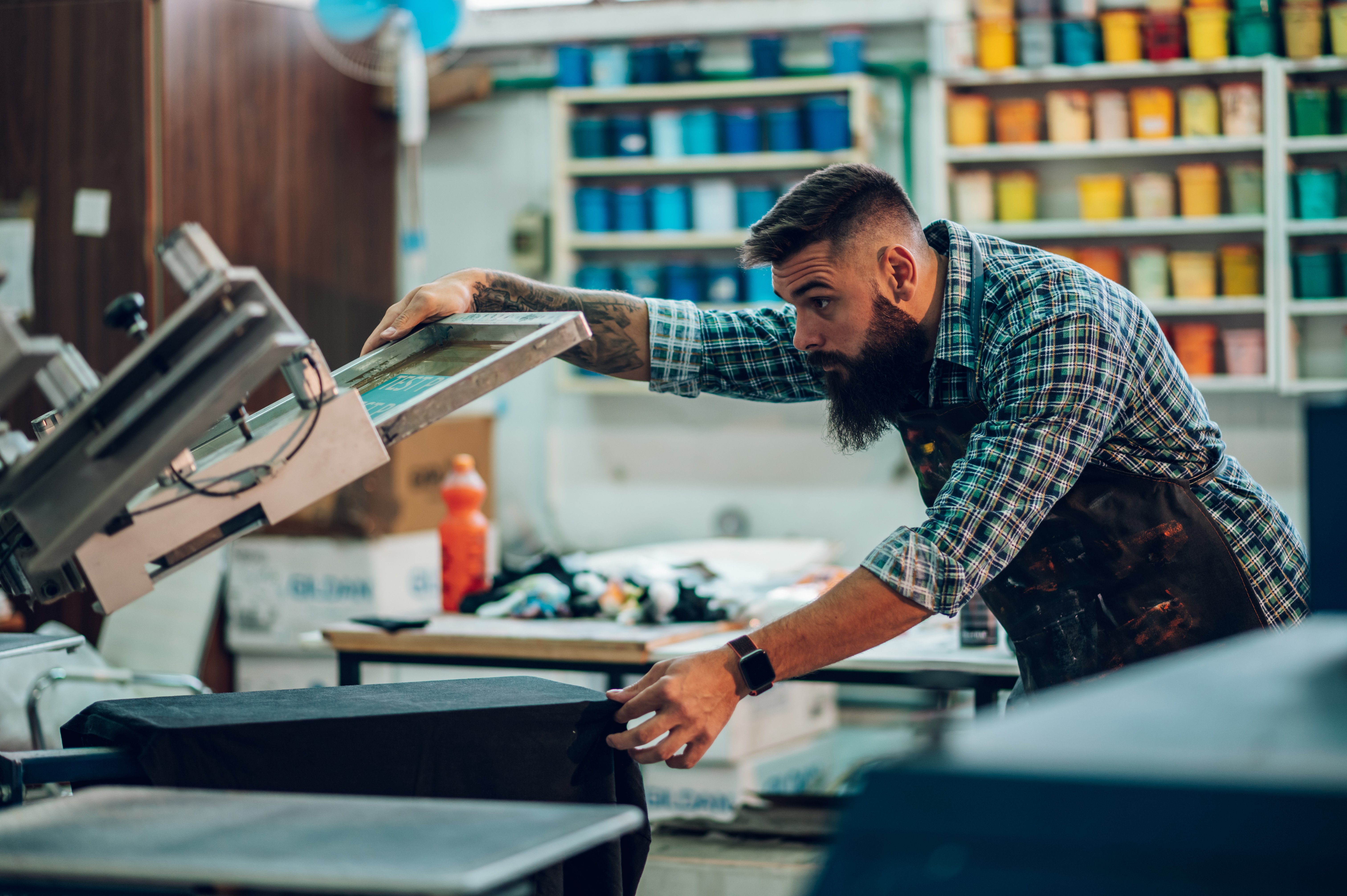 male using printing machine in workshop